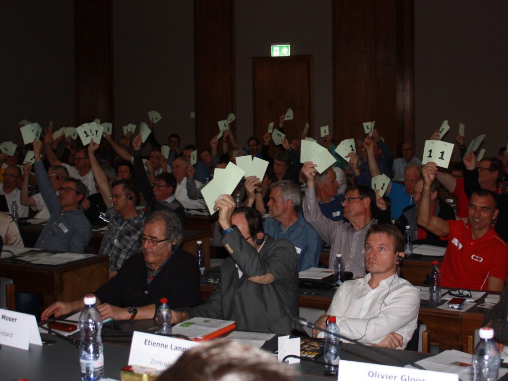 Teilnehmende der Delegiertenversammlung von Swiss Athletics in Sion stimmen über ein Geschäft ab