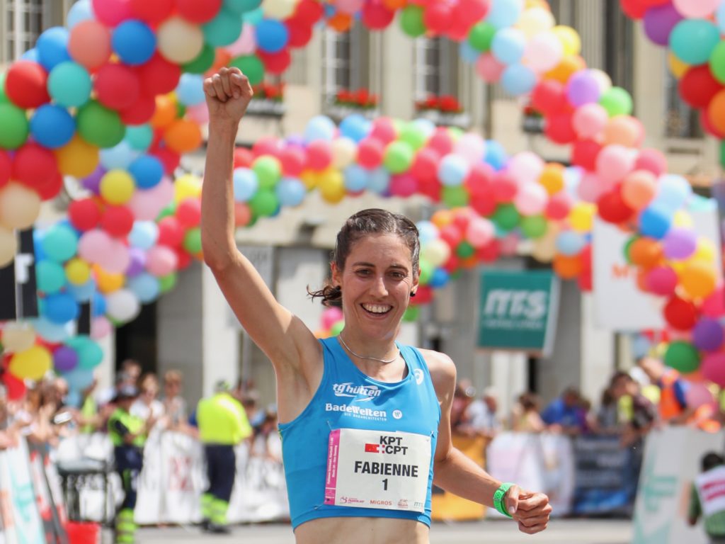 Fabienne Schlumpf läuft beim Frauenlauf 2018 als Siegerin über 5 km über die Ziellinie und hebt jubelnd den Arm